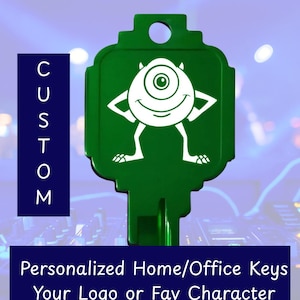 May include: A green house key featuring a white graphic of a one-eyed monster character. The text CUSTOM is printed vertically on the left, and the text Personalized Home/Office Keys Your Logo or Fav Character is printed at the bottom.