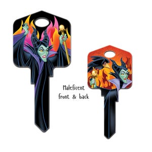 Puede incluir: Dos llaves decorativas con Mal&eacute;fica de La Bella Durmiente de Disney. Una llave muestra a Mal&eacute;fica con un bast&oacute;n sobre un fondo de fuego. La otra llave muestra a Mal&eacute;fica con un cuervo y un fondo de fuego. Tambi&eacute;n se ve el texto "Mal&eacute;fica delante y detr&aacute;s".