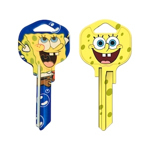 May include: Two decorative house keys featuring the cartoon character SpongeBob SquarePants. One key has a blue top with SpongeBob's face, the other is yellow with SpongeBob's face. Both keys have a yellow body.