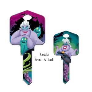Puede incluir: Dos llaves decorativas con Ursula de La Sirenita. Una llave muestra a Ursula con Flotsam y Jetsam sobre un fondo morado y negro. La otra llave muestra a Ursula con sus tent&aacute;culos sobre un fondo turquesa.