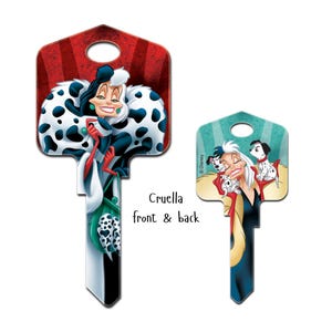Puede incluir: Dos llaves decorativas para el hogar con Cruella de Vil de 101 D&aacute;lmatas de Disney. Una llave muestra a Cruella con un abrigo de piel manchado en blanco y negro sobre un fondo rojo. La otra llave muestra a Cruella con cachorros d&aacute;lmatas.
