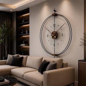 Puede incluir: Un gran reloj de pared circular con un marco de metal negro de dos anillos concéntricos, un centro de madera y manecillas negras delgadas. La esfera es transparente con números negros minimalistas en las posiciones de las 12, 3, 6 y 9.