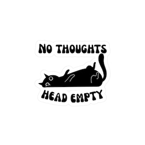 Può includere: Un adesivo nero con un gatto dei cartoni animati sdraiato sulla schiena. Il testo "NO THOUGHTS HEAD EMPTY" è in grassetto, con un carattere arrotondato. Il gatto ha un design minimalista con una coda curva e piccoli dettagli.
