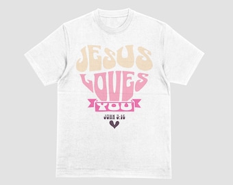 May include: White t-shirt with the text "JESUS LOVES YOU" in a retro font. The word "LOVES" is in a heart shape. Below the heart is the text "JOHN 3:16" and a small black heart. The shirt is a classic crew neck.