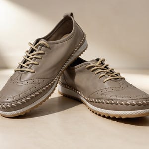 Front view of beige handmade leather flats with flat sole and everyday design