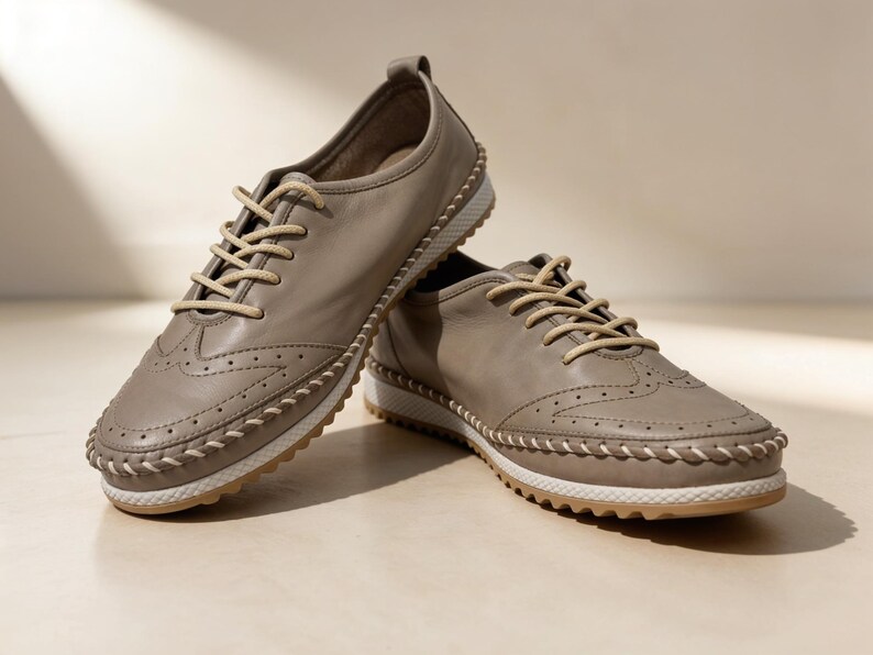 Front view of beige handmade leather flats with flat sole and everyday design