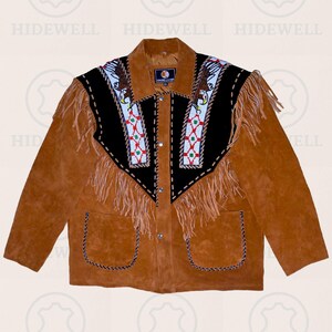 Könnte beinhalten: Braune Wildlederjacke mit dekorativen Fransen und Perlenarbeiten. Die Jacke hat einen schwarzen Einsatz mit weißen, roten und blauen Perlenarbeiten und zwei Vordertaschen. Die Jacke hat eine Knopfleiste und ist im klassischen Western-Stil gehalten.