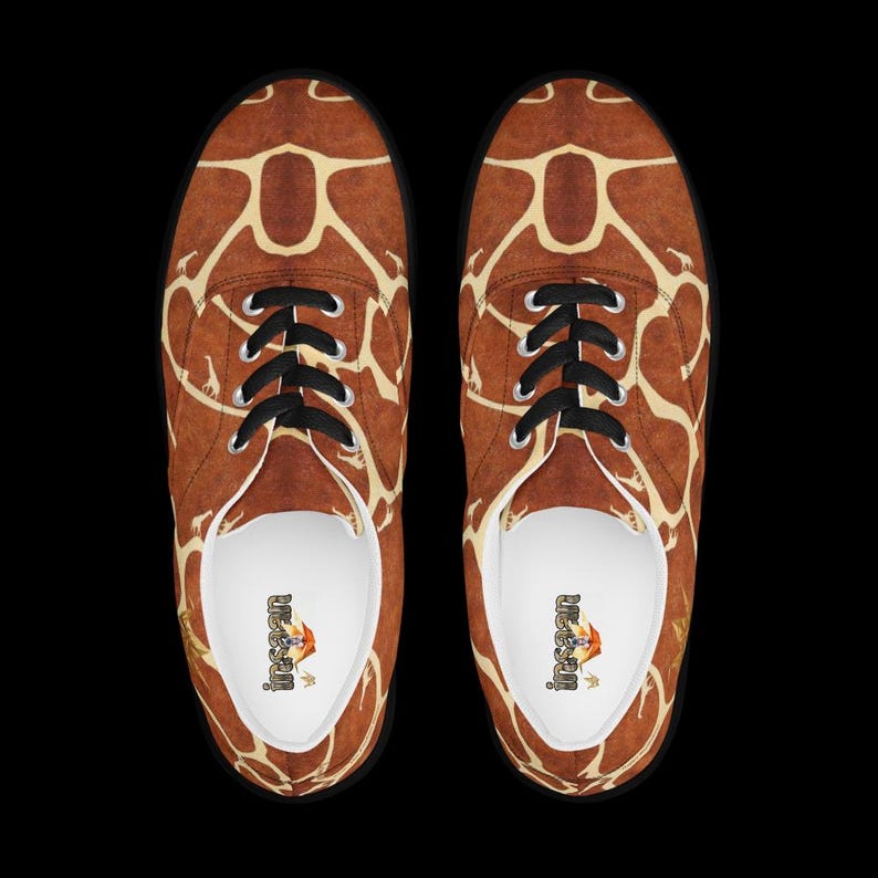 May include: A pair of low-top sneakers featuring a brown and cream giraffe-inspired pattern across the exterior. The shoes have black laces, silver-toned eyelets, and white interior linings with the brand name Insan printed on the insoles.