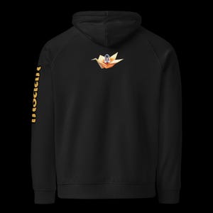 May include: Black hoodie with a hood and long sleeves. The back features a small illustration of an astronaut in an origami crane. The left sleeve has the word "PRODIGY" printed vertically in gold.
