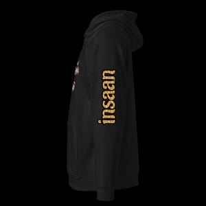 May include: Black hoodie with the word "insaan" printed in a gold, textured font down the right sleeve. The hoodie has a front pocket and a hood. The word "insaan" is also printed on the front of the hoodie.