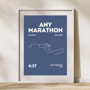 Könnte beinhalten: Gerahmter Druck mit dem weißen Text "ANY MARATHON" auf marineblauem Hintergrund. Der Druck zeigt eine weiße Strichzeichnung einer Rennstrecke, die Distanz von 42,195 km und das Datum 10.02.2025. Die Zeit 4:37 und der Name Molly Burrows sind ebenfalls angegeben.