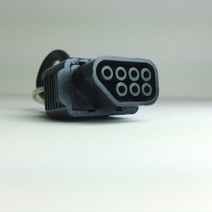 May include: A black connector with eight round holes, likely for an electronic device.