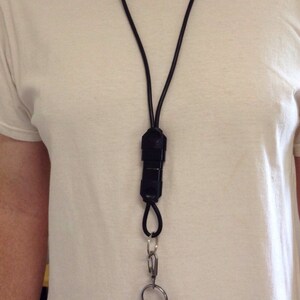 May include: A black key chain with a black lanyard and a silver key ring with multiple keys attached.