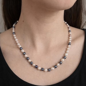 May include: A white ceramic mug adorned with a vibrant floral pattern. The mug has a handle and is designed for hot drinks. The floral design showcases flowers and foliage in pinks, purples, and greens.