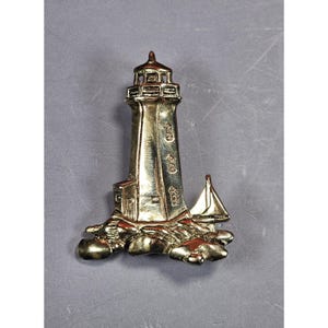 Vintage vuurtoren- en zeilbootspeld goudkleurig