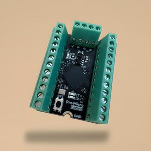 May include: A black Pro Micro Embed microcontroller board featuring two long green screw terminal blocks on the sides and one smaller green screw terminal block at the top. The board includes various electronic components and white text labels.