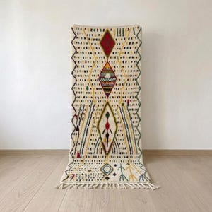 Moroccan runner rug in ivory wool, hand-knotted hallway runner with colorful seed motifs and black dotted pattern