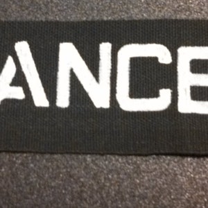 May include: Black fabric patch with the word "LANCEIR" printed in white.