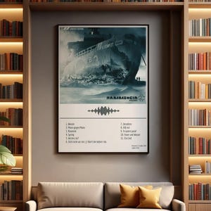 May include: A framed poster featuring a grayscale image of a ship at sea, with the band name and a list of song titles below. The poster is displayed on a neutral wall between two bookshelves filled with books. A sofa with yellow pillows sits below.