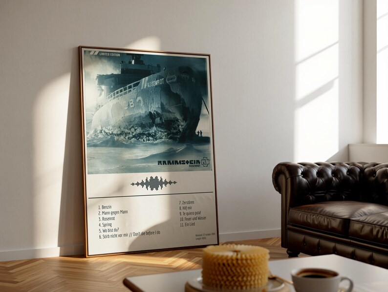 May include: A framed poster featuring a distressed image of a ship, with the band name "Rammstein" and a tracklist. The poster has a beige background and a wooden frame. The image is in shades of blue and gray, with the text "Limited Edition" at the top.