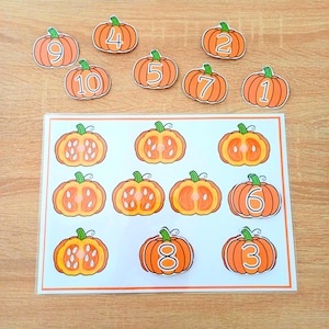 Peut inclure: Un ensemble de découpages éducatifs sur le thème des citrouilles et une fiche d'activité rectangulaire. Les citrouilles orange portent des chiffres blancs de 1 à 10. La fiche présente des illustrations de citrouilles entières et coupées.