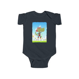 Puede incluir: Body de bebé azul marino oscuro con un cocodrilo de dibujos animados con una bufanda a cuadros rojos y blancos, botas cohete y una mochila cohete. El cocodrilo está sobre un campo verde con un cielo azul. El body está hecho de material suave y cómodo.