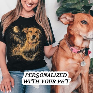 May include: A black short-sleeved t-shirt featuring a golden-toned graphic illustration of a dog in a forest setting under a full moon. The design includes a smaller dog silhouette and starry details. The text PERSONALIZED WITH YOUR PET is visible.