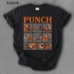Peut inclure: T-shirt noir avec le mot "PUNCH" en lettres orange. Le t-shirt pr&eacute;sente une grille de neuf carr&eacute;s, chacun avec une illustration diff&eacute;rente de deux singes qui s'embrassent. Le mot "black" est dans le coin sup&eacute;rieur gauche.