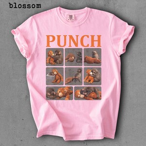 Peut inclure: T-shirt rose clair avec le mot "PUNCH" en lettres orange. En dessous, neuf carr&eacute;s avec des illustrations de singes. Les manches sont retrouss&eacute;es.