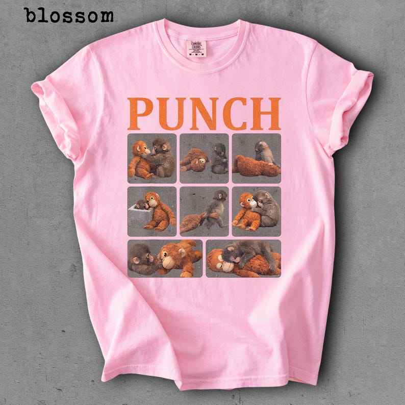 Peut inclure: T-shirt rose clair avec le mot "PUNCH" en lettres orange. En dessous, neuf carr&eacute;s avec des illustrations de singes. Les manches sont retrouss&eacute;es.