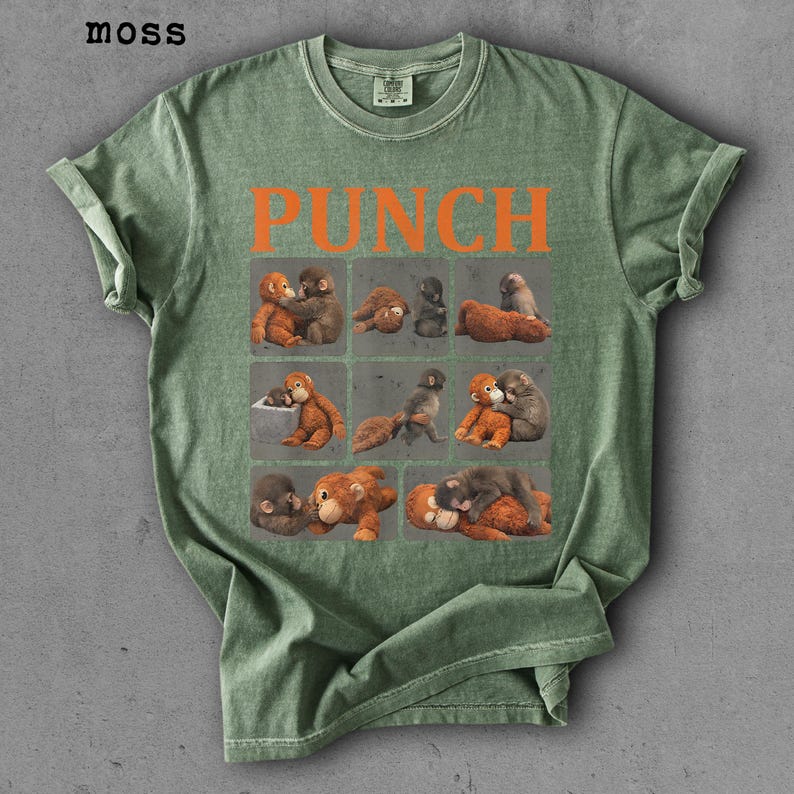 Peut inclure: T-shirt vert avec le mot "PUNCH" en lettres orange. Le t-shirt pr&eacute;sente une grille de neuf carr&eacute;s, chacun avec une illustration diff&eacute;rente de singes. Le t-shirt est de couleur vert mousse.