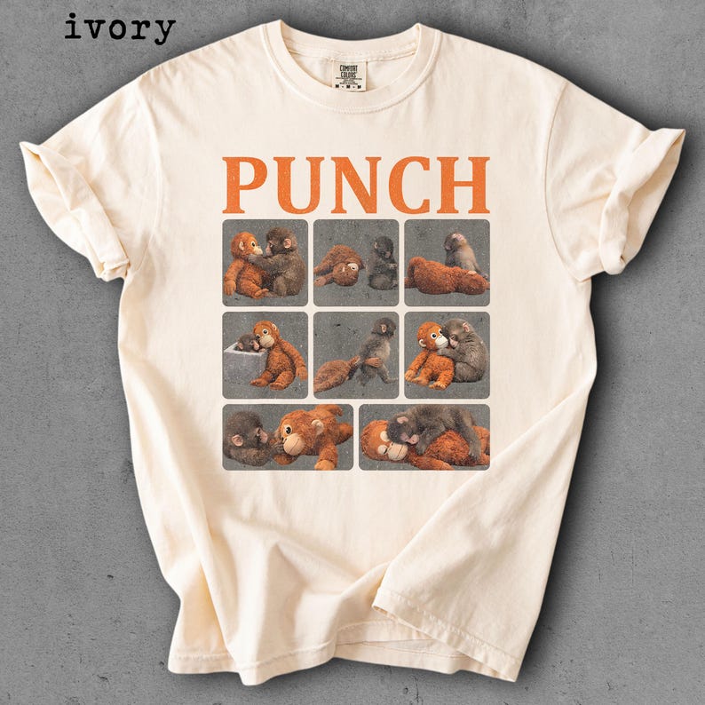 Peut inclure: T-shirt ivoire avec le mot "PUNCH" en lettres orange. En dessous, neuf carr&eacute;s avec des illustrations d'orang-outans. Le t-shirt est en mati&egrave;re douce.
