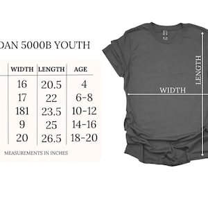 May include: A dark gray t-shirt displayed next to a Gildan 5000B Youth sizing chart. The chart lists sizes XS through XL with corresponding width and length measurements in inches, alongside age ranges for each size, providing a clear visual guide.