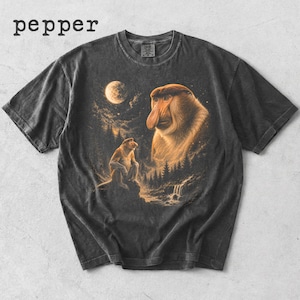May include: Dark gray t-shirt featuring a detailed illustration of two proboscis monkeys in a forest setting under a full moon. The word "pepper" is printed at the top left.