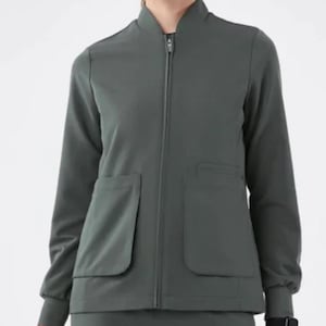 Könnte beinhalten: Dunkelgrüne Jacke mit Reißverschluss, zwei Vordertaschen und passender Hose. Die Jacke hat einen Stehkragen und lange Ärmel. Das Outfit besteht aus einem glatten, knitterarmen Stoff, der für medizinisches Fachpersonal geeignet ist.