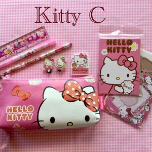 May include: Pink Hello Kitty pencil case with a zipper closure, a pink Hello Kitty ruler, a pink Hello Kitty pen, a pink Hello Kitty pencil, two Hello Kitty hair clips, and a pink Hello Kitty notepad with a Hello Kitty sticker.