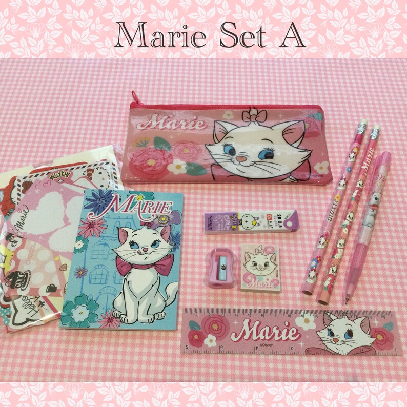 May include: A pink and blue Marie stationery set with a pencil case, a notebook, a ruler, a pencil sharpener, an eraser, and pencils. The set features a cartoon image of Marie the cat from the Disney movie The Aristocats.