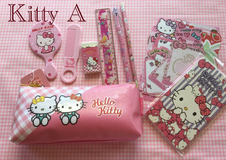 May include: A pink Hello Kitty pencil case with two Hello Kitty characters on the front. The case is filled with Hello Kitty themed school supplies, including a comb, mirror, eraser, ruler, pencils, and stickers.