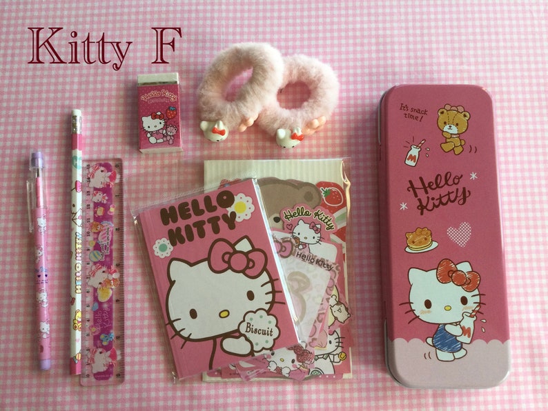 May include: A pink Hello Kitty pencil case, a pink Hello Kitty notebook, a pink Hello Kitty eraser, two pink fuzzy hair ties, a pink pencil, a pink pen, and a pink ruler with Hello Kitty and unicorn designs. The background is a pink and white gingham pattern.