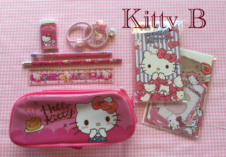 May include: Pink Hello Kitty pencil case with a Hello Kitty design, a pink ruler, two pencils, a pink eraser, and a Hello Kitty notepad and stickers.