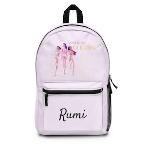 Może przedstawiać: Biały plecak z czarnym zamkiem błyskawicznym i boczną kieszenią z siatki. Z przodu grafika trzech postaci z napisem "Gonna be GOLDEN" i imieniem "Rumi" czarnym pismem.