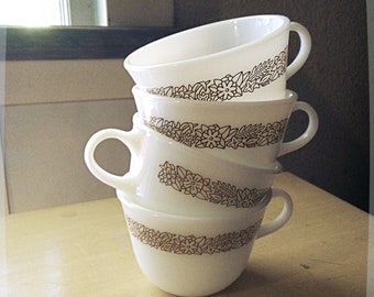 Xícaras Pyrex vintage em vidro leitoso com estampa de floresta.
