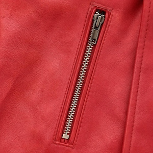 May include: A bright red jacket featuring a smooth, textured surface and a vertical zippered pocket. The pocket is secured with a metallic silver zipper pull and teeth, set against the vibrant red material with visible stitched seam detailing.
