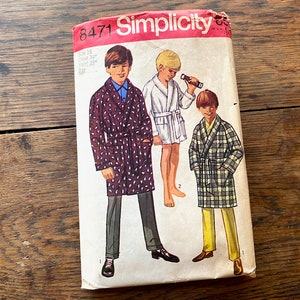 May include: Simplicity sewing pattern number 8471 for boys' robes. The pattern shows three boys wearing different robes, one in a brown and white patterned robe, one in a white robe, and one in a plaid robe.