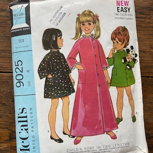 May include: Vintage McCall's sewing pattern for a child's robe in two lengths. The pattern is for sizes 4 and 8. The pattern includes a two-color guide and is labeled "New Easy".