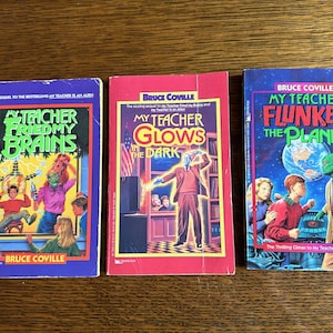 May include: Three paperback books with colorful covers featuring the title "My Teacher Fried My Brains", "My Teacher Glows in the Dark", and "My Teacher Flunked the Planet". All three books are part of the same series and feature illustrations of aliens.
