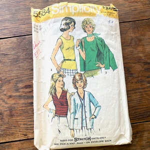 May include: A vintage Simplicity sewing pattern envelope with the number 5584 printed on the front. The envelope features illustrations of four women wearing different outfits. The text "SIZED FOR STRETCH KNITS ONLY" and "SEE PICK-A-KNIT RULE ON ENVELOPE BACK" is printed on the bottom of the envelope.