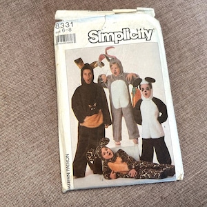 May include: A Simplicity pattern package featuring children in animal costumes: a cat, a bunny, a panda, and a leopard. The package is white with the Simplicity logo and pattern number 8331.