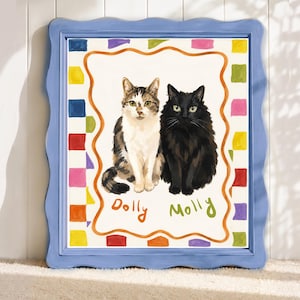 Op de afbeelding: Een ingelijst kunstwerk met twee katten, een tabby en een zwarte, die naast elkaar zitten. Het kunstwerk heeft een witte achtergrond, een kleurrijke rand en een golvende blauwe lijst. De namen "Dolly" en "Molly" staan eronder.