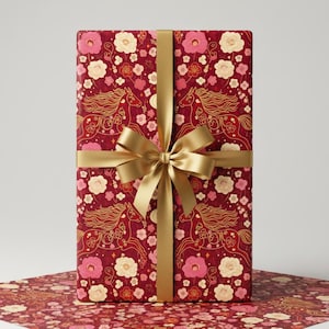 Peut inclure: Un cadeau emballé avec un motif floral et de chevaux bordeaux, noué avec un ruban et un nœud dorés. Le papier d'emballage présente un motif répété de fleurs et de chevaux dorés et roses.